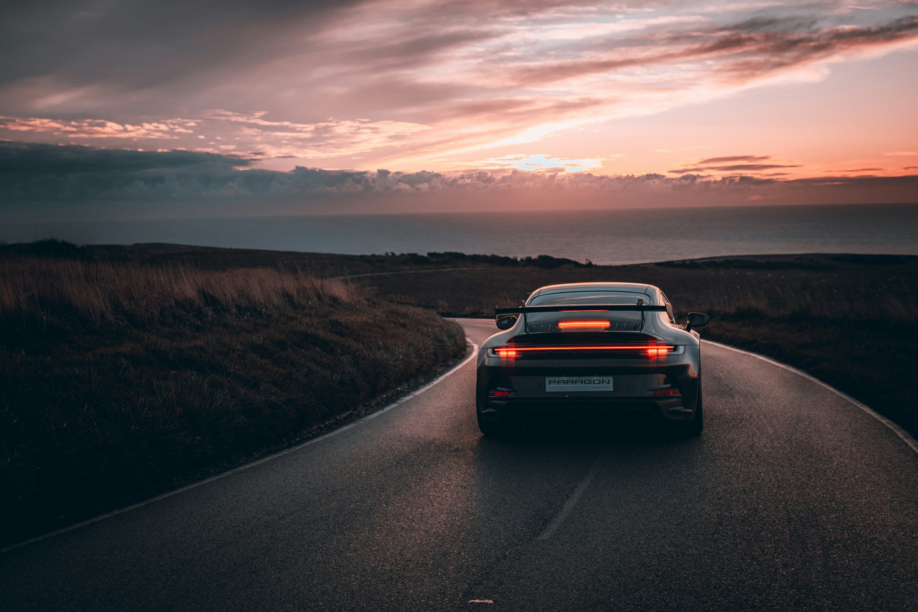 Sportwagen auf einer Straße bei Sonnenuntergang